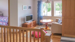 A cozy room with a bed, a TV, a dining table, and a sofa. - 4 bedroom beautiful home in Gnosjö (Gnosjö)