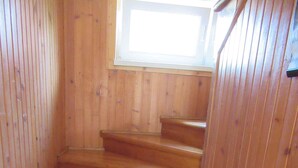 Una escalera de madera con un ventanal en la parte superior.