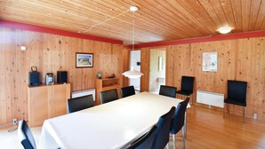 A room with a wooden ceiling, a white table with chairs, a globe, a speaker, and framed pictures on the walls. - 5 bedroom nice home in Væggerløse (Væggerløse)