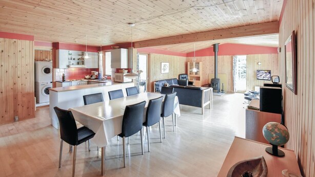 A spacious living area with a large dining table, a sofa, and a fireplace. - 5 bedroom nice home in Væggerløse (Væggerløse)