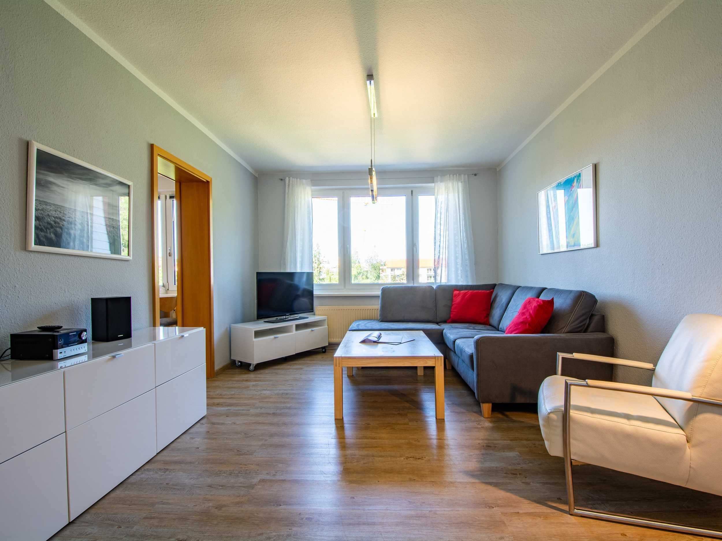 A modern living room with a sofa, a coffee table, a TV, and a cabinet.