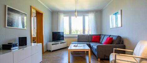 A modern living room with a sofa, a coffee table, a TV, and a cabinet.