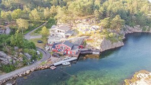 A lakeside property with a dock, clear water, and a red house. - 3 bedroom awesome home in Lyngdal (Lyngdal)