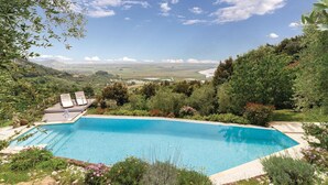 A swimming pool with a view of a valley and distant mountains.