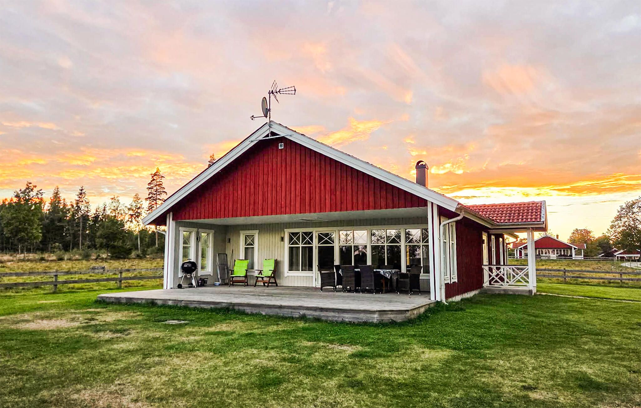 A red barn with a covered porch, a satellite dish, and a chimney.