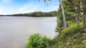 A calm lake with dense forest on the opposite shore.