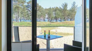 Un balcón con una mesa, dos sillas y dos botellas de vino.