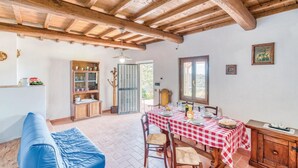 A rustic dining area with a checkered tablecloth, wooden furniture, and a view through a window. - Nice apartment in Loro Ciuffenna AR (Loro Ciuffenna AR)