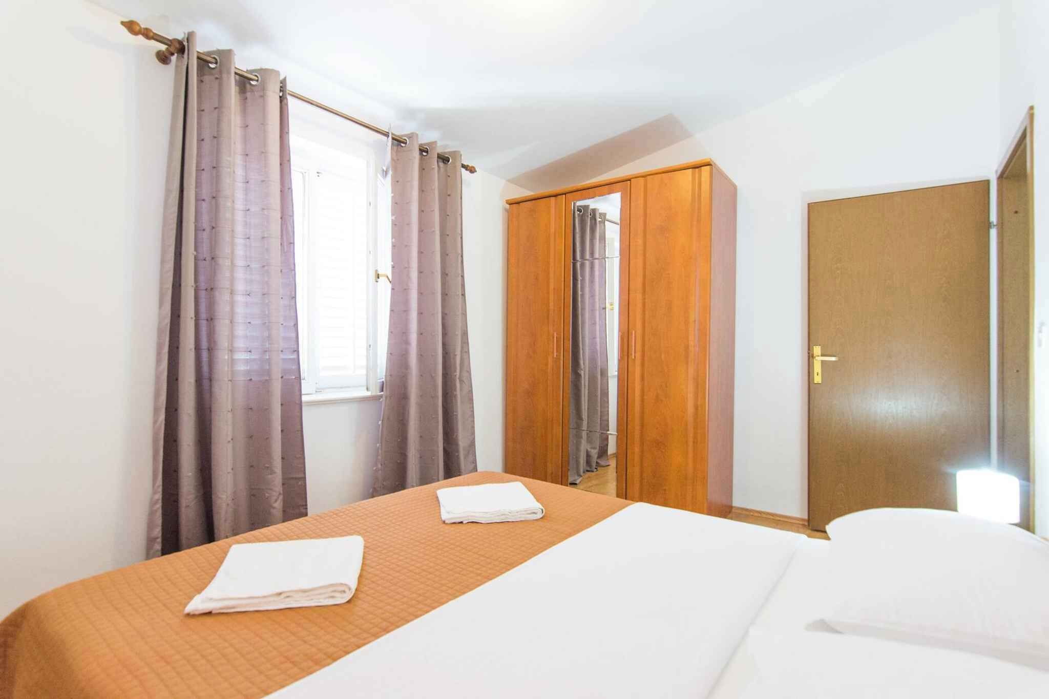 Une chambre d’hôtel avec un lit, une fenêtre avec des rideaux, une armoire et une porte.