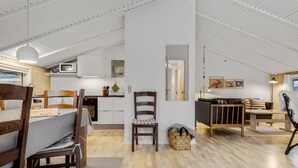 Ampla sala de estar estilo loft, com pé direito alto, piso de madeira e uma mistura de móveis modernos e rústicos.