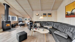 Una sala de estar acogedora con chimenea, sofá de cuero y suelo de madera.