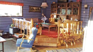 A cozy room with a rocking chair, a wooden table, and a bookshelf.