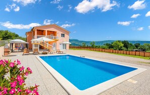 A two-story building with a pool, outdoor seating, and a view of mountains. - Lovely home in Podpican (Podpican)