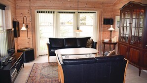 A cozy cabin interior with a sofa, a small table, a cabinet, and a television. - Amazing home in Tranekær with sauna (Tranekær)