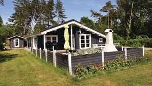A cabin with a porch, a chimney, and a fenced yard. - Amazing home in Tranekær with sauna (Tranekær)