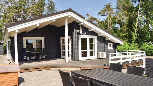 A cabin with a covered patio, outdoor seating, and a deck. - Amazing home in Tranekær with sauna (Tranekær)