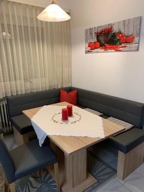 A dining area with a table, chairs, and a sofa. - Apartment on the Wiesent - Apartment An der Wiesent (Ebermannstadt)