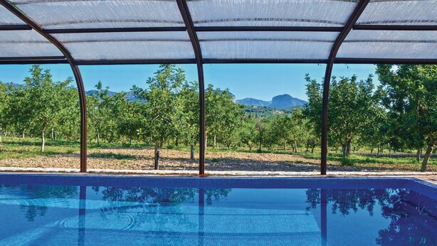 Une piscine offrant une vue dégagée sur les arbres et les montagnes en arrière-plan.