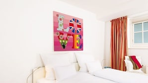 A neatly made bed with white linens, a wall art piece with the word "LOVE" and a British flag, and a window with curtains. - Kampen-Kliff 3 from A&M - Kampen-Kliff 3 (Kampen (Sylt))