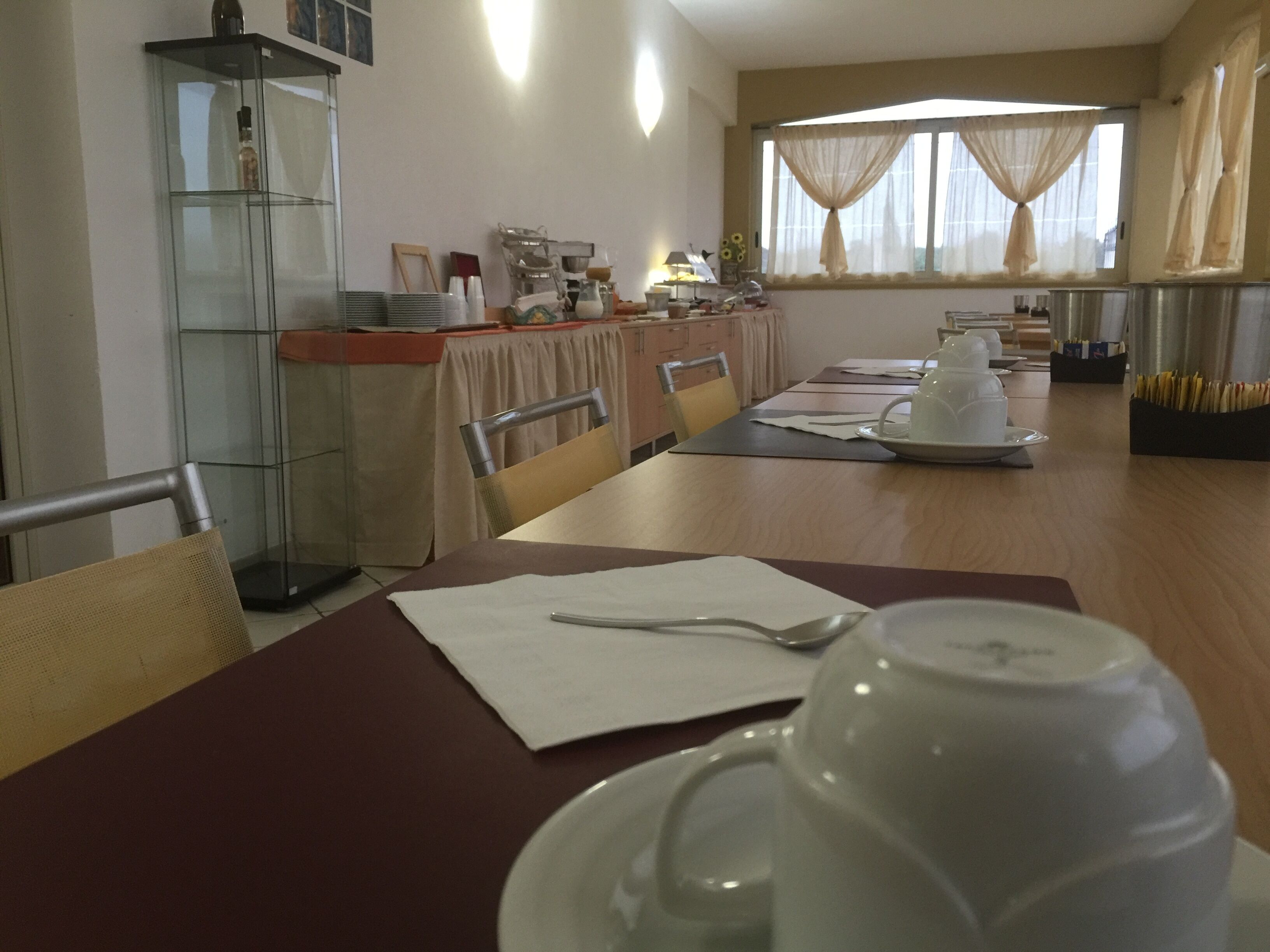 A dining area with a long table, chairs, and a coffee machine.