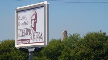 A billboard advertising a hotel with services like room and breakfast, Wi-Fi, and a view of the sea.