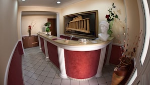 A reception area with a marble counter, a bust sculpture, and a framed picture of columns. - B&B Il Tempio di Hera (Castelvetrano)