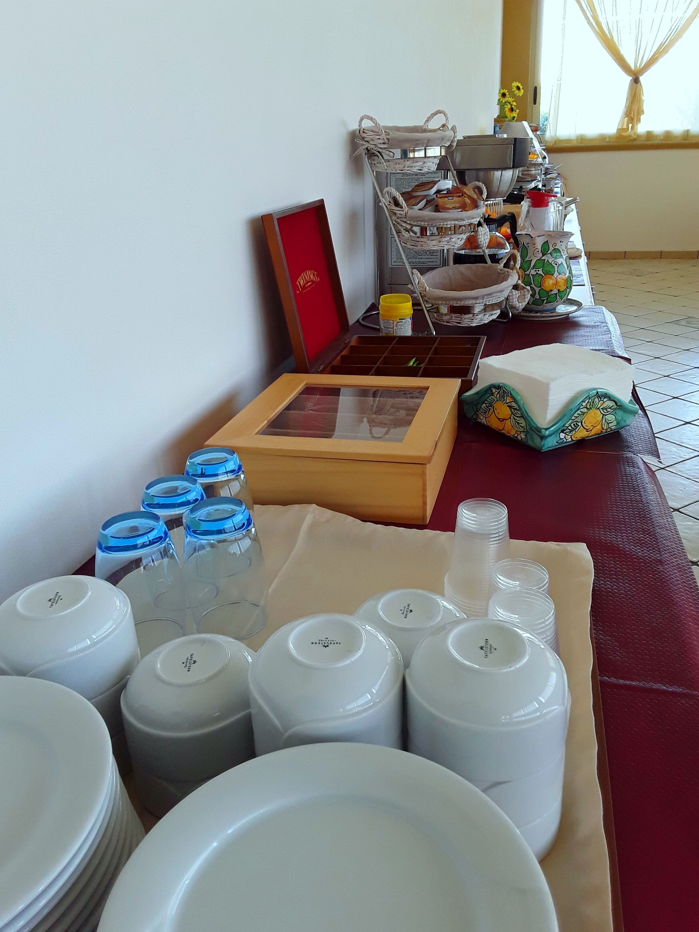 Une table dressée avec des assiettes, des bols et un panier de pain.