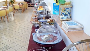 A buffet setup with various food items and a coffee station. - B&B Il Tempio di Hera (Castelvetrano)