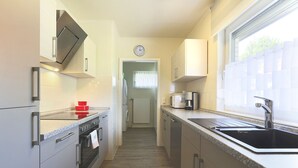 A modern kitchen with stainless steel appliances, a built-in oven, a microwave, and a sink.