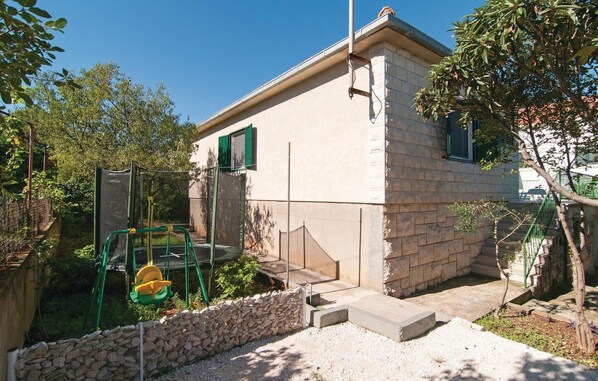 A small building with a stone facade, a green door, and a small porch area.