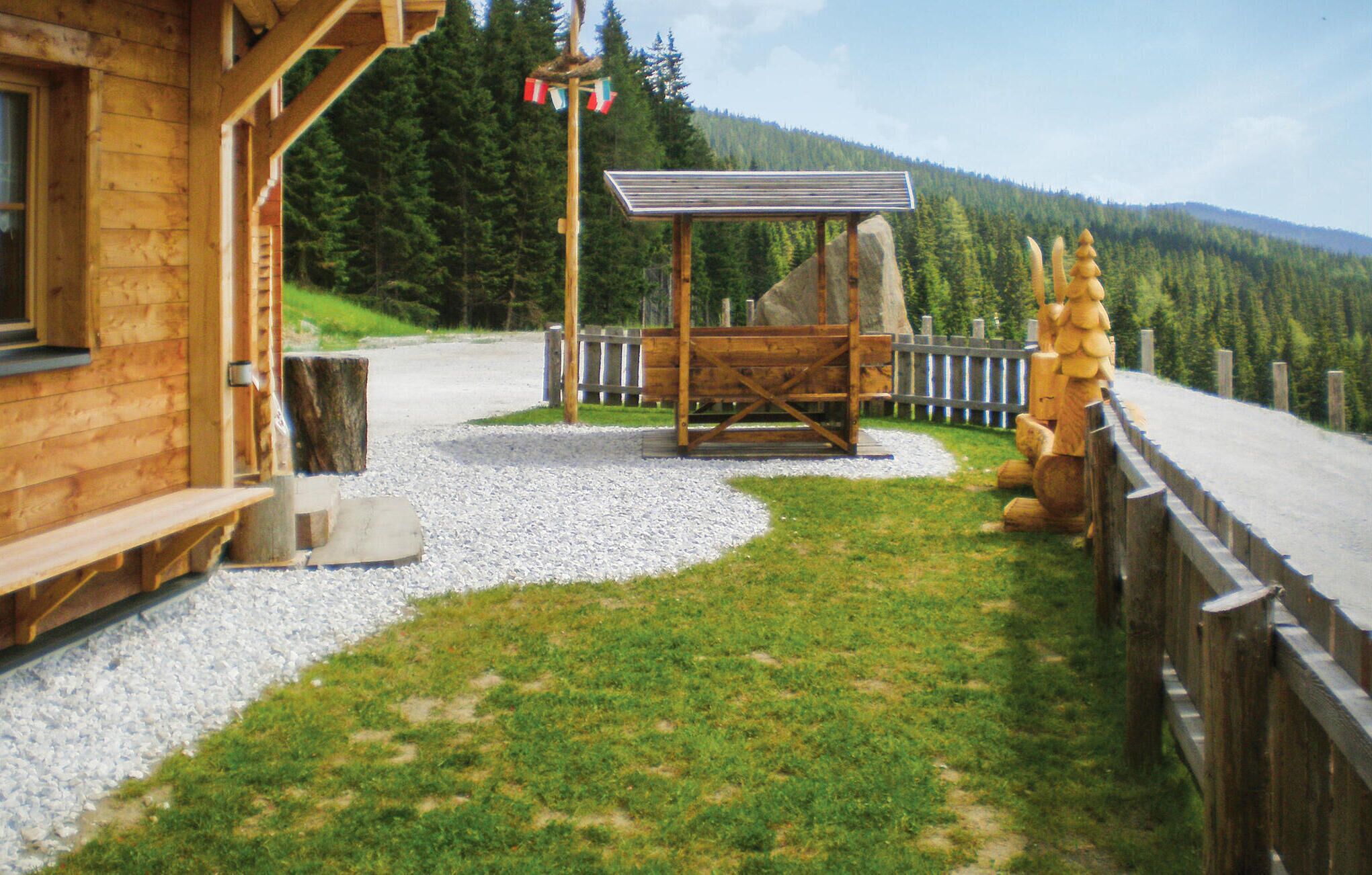 Une cabane en bois avec un chemin de gravier menant à un kiosque en bois.