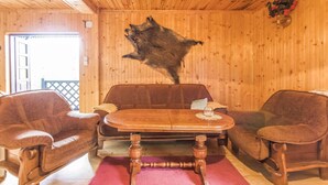 A wooden interior with a mounted animal hide on the wall, a wooden table, and leather chairs. - 3 bedroom cozy home in Dabrówno (Dabrówno)
