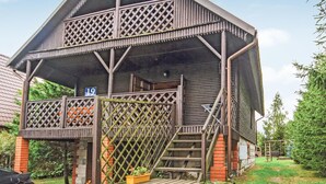 A two-story wooden structure with a balcony and a staircase leading to the entrance. - 3 bedroom cozy home in Dabrówno (Dabrówno)