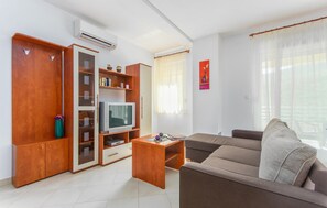 A living room with a sofa, TV, wooden cabinet, and a small table. - Lovely apartment in Labin with WiFi (Labin)