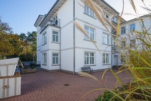 Ein mehrstöckiges Gebäude mit flachem Dach, einem Balkon und einem Ziegelhof.