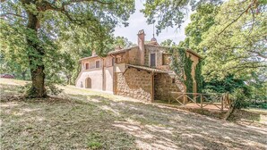 A stone building with a sloped roof, a small porch, and a wooden fence. - 3 bedroom awesome home in Montefiascone (VT) (Montefiascone (VT))