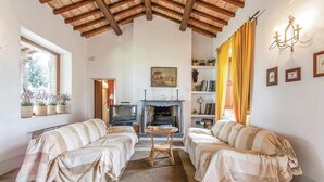 A cozy living room with two sofas, a fireplace, a television, and a bookshelf. - 3 bedroom awesome home in Montefiascone (VT) (Montefiascone (VT))