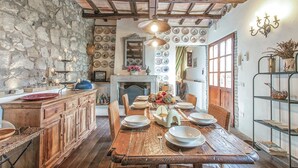 A rustic dining room with a stone wall, wooden beams, and a fireplace. - 3 bedroom awesome home in Montefiascone (VT) (Montefiascone (VT))