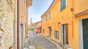 A narrow street with buildings on either side, including a building with a visible number '19'.