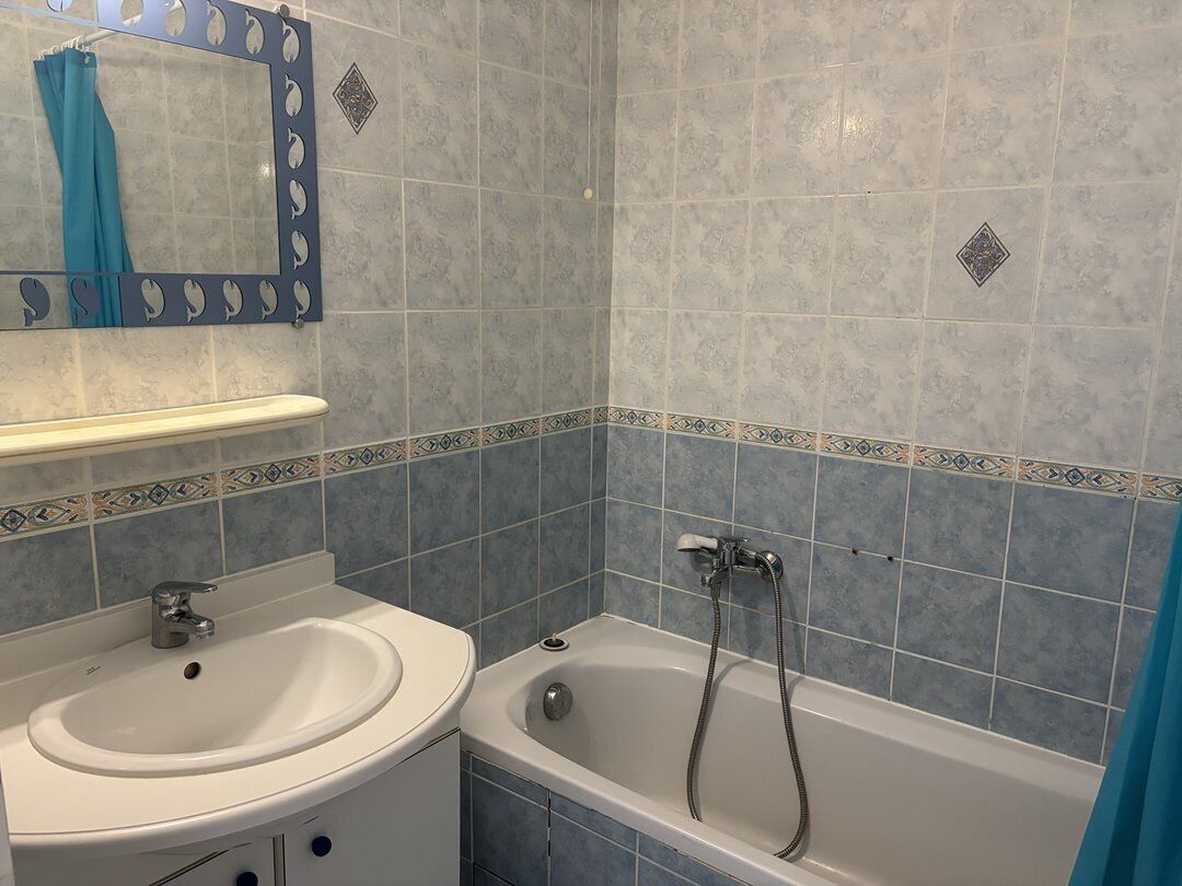 A bathroom with a sink, mirror, and bathtub.