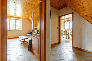 A spacious room with a wooden ceiling, a dining area with a table and chairs, and a large window with curtains. - Homerez - Apartment in Epfig (Epfig)