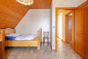 A bedroom with a wooden bed, a chair, and a wooden wardrobe. - Homerez - Apartment in Epfig (Epfig)