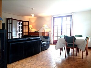 Relax in this stylish living room with a comfortable sofa, dining area, and large window.