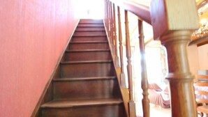 Un escalier en bois avec une rampe, qui monte.