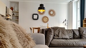 A modern living room with a grey sofa, a patterned armchair, and a fluffy throw. - N&J - COLIBRI PRESTIGE - Central - By sea (Niza)