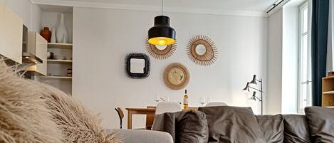 A modern living room with a grey sofa, a patterned armchair, and a fluffy throw.