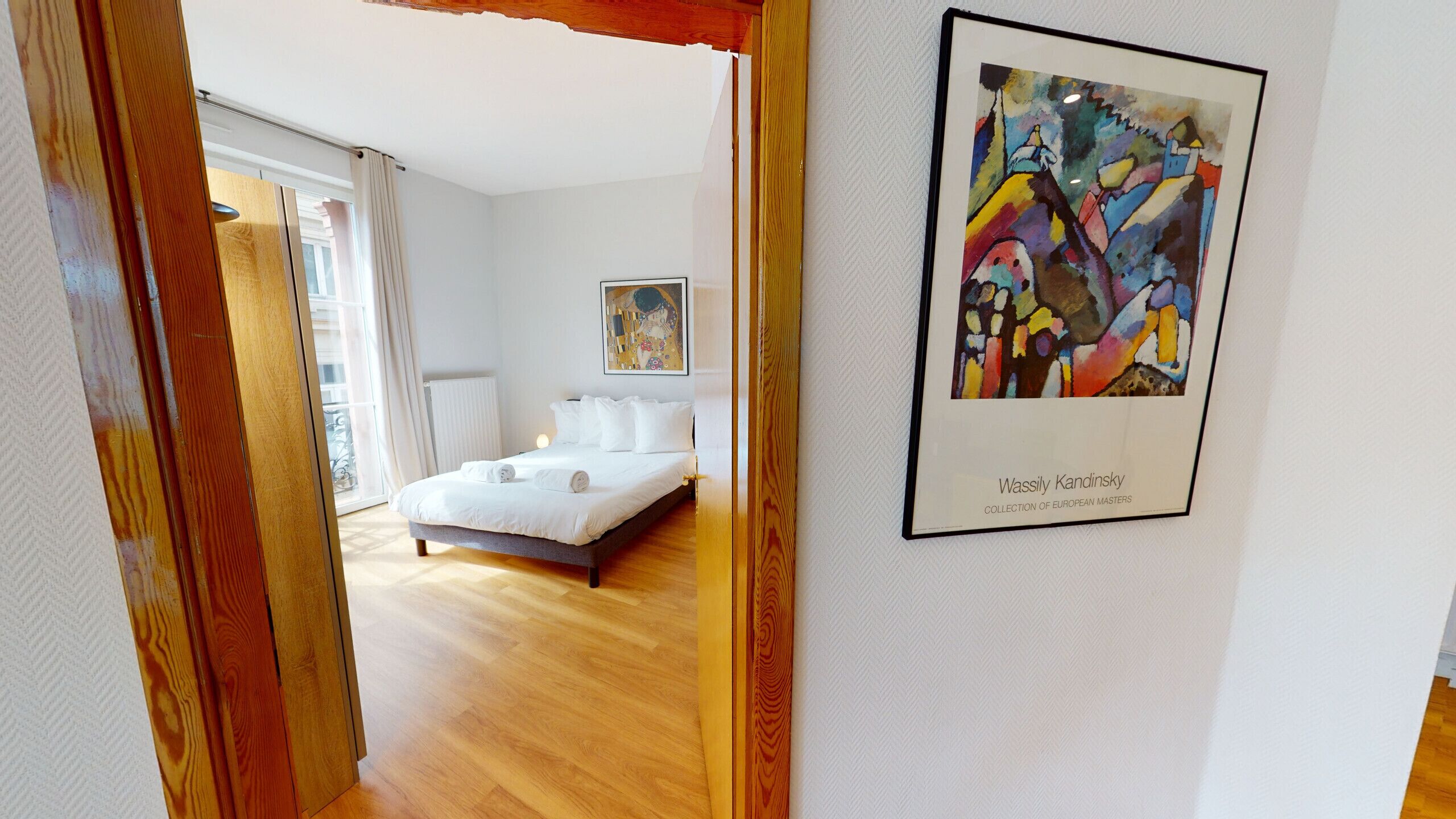 Une chambre d’hôtel avec un lit, un tableau et une vue sur l’extérieur.
