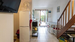 A kitchen with a refrigerator, microwave, and a fan. There is a staircase leading to another room. - Homerez - House in Argelès-sur-Mer with shared pool (Argelès-sur-Mer)