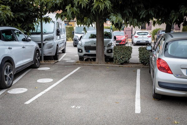 Ein Parkplatz mit mehreren Autos und einem Baum in der Mitte.