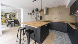A modern kitchen with a central island, black cabinets, and pendant lighting. - Balthazar, 4BR/4BA, 9 people (París)